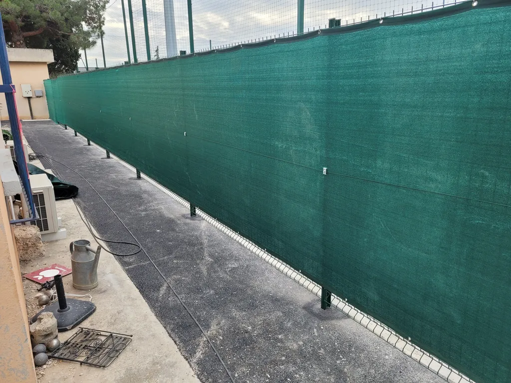 Installation de tissus brise-vue ourlés sur clôtures pour un terrain de sport à Marseille dans les Bouches du Rhône