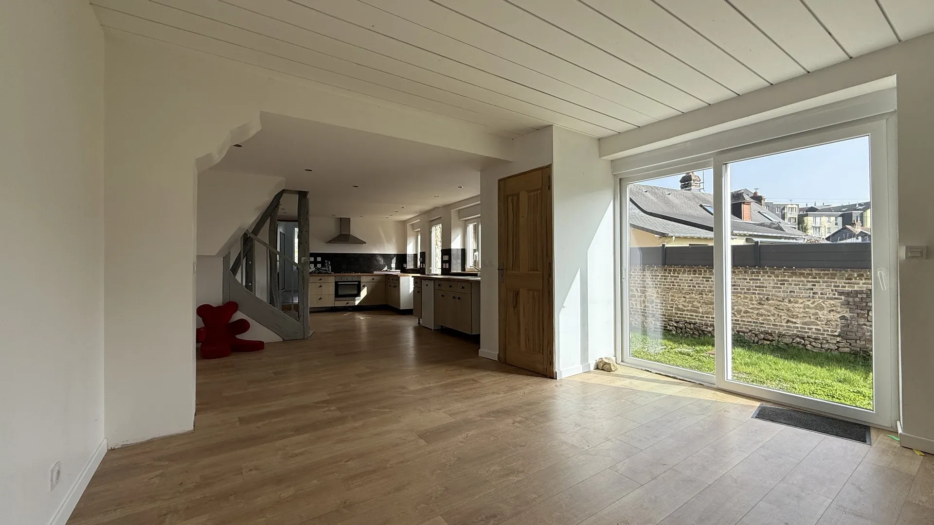 Le rez-de-chaussée de ce bien immobilier à vendre à Neufchâtel-en-Bray comprend une entrée avec interphone, une buanderie et une cuisine aménagée et équipée ouverte.