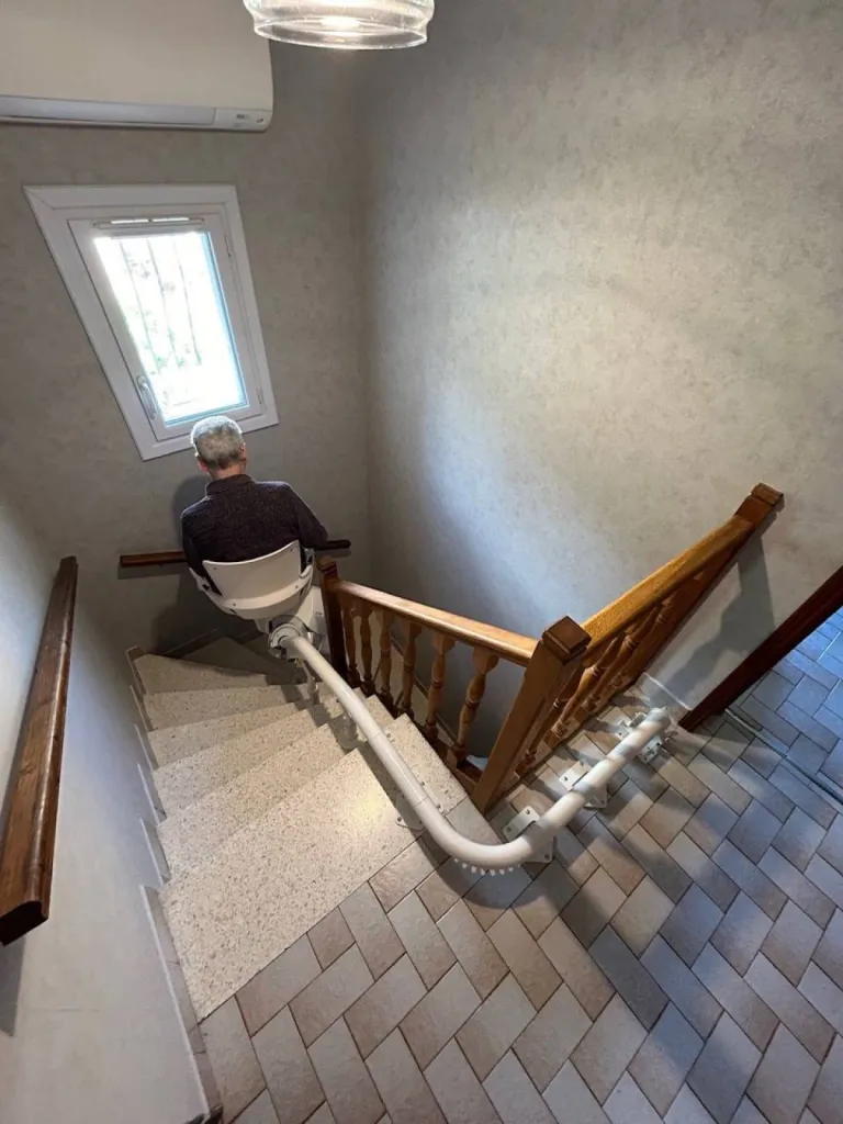 L'essayer c'est l'adopter, pour ce senior sur son fauteuil monte escalier OTOLIFT Modul'Air Smart dans un escalier 2/4 tournant en intérieur près de Marseille