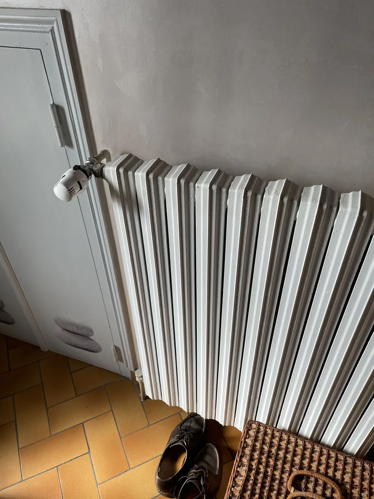 Radiateur en fonte alimenté par un chauffage central dans une maison du Beaujolais (Rhône 69), pouvant être impacté par l’encrassement du circuit