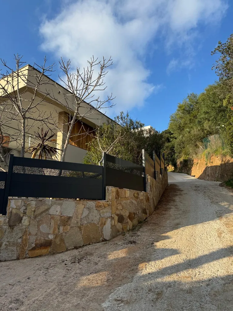 Fermeture d'une propriété à Porticcio : portail Tschoeppé Linéo Life motorisé Ghostopener, 60 m de clôtures en pente, muret parmé de pierre naturelle