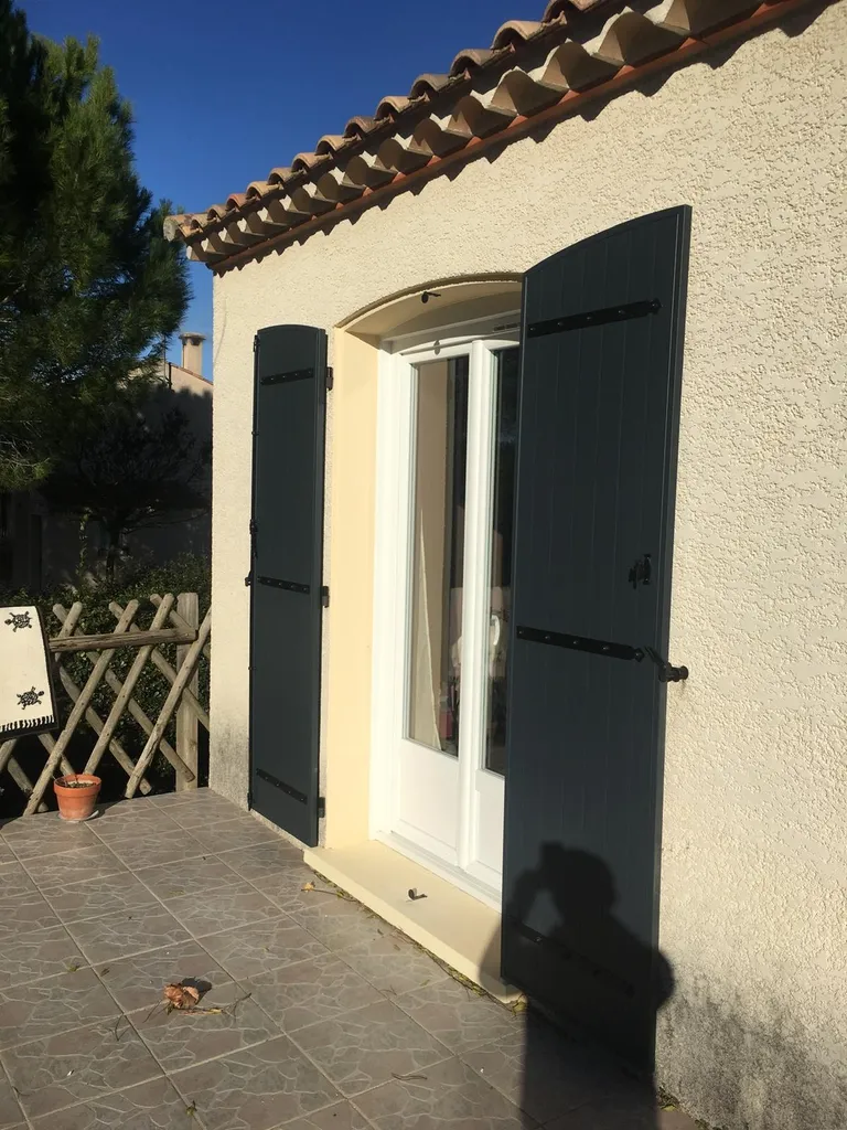 Installation d’une porte-fenêtre PVC blanc et volets battants RAL 7016 dans la commune de Aumes Aumes –  Fabrication française