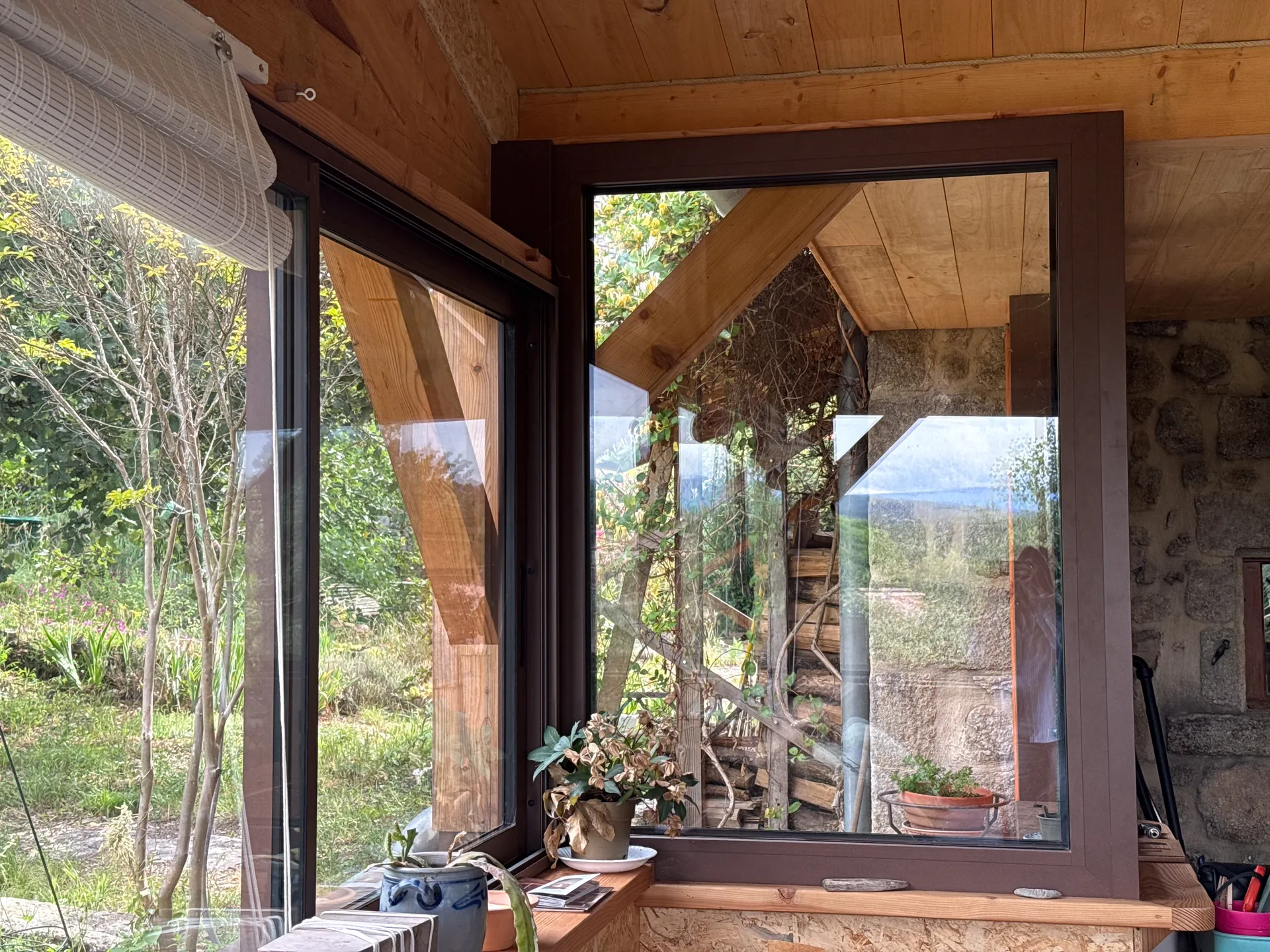 Fermeture d'une terrasse ardéchoise sous charpente bois avec de grands coulissants aluminium teinte rouille