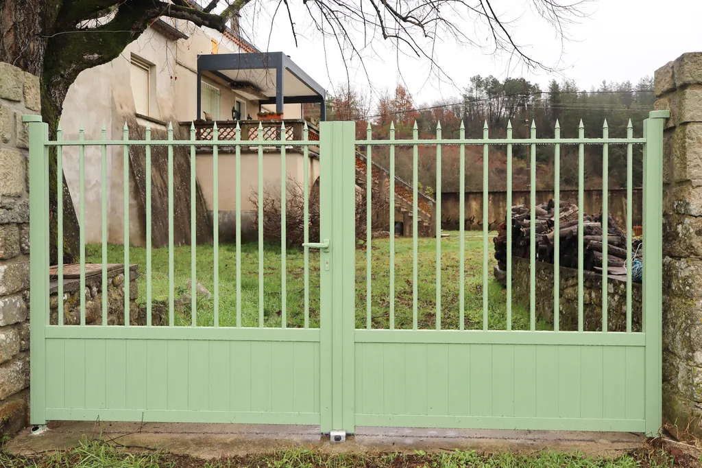 Un portail battant vert sauge qui redonne du caractère à l’entrée et souligne l’âme du jardin familial