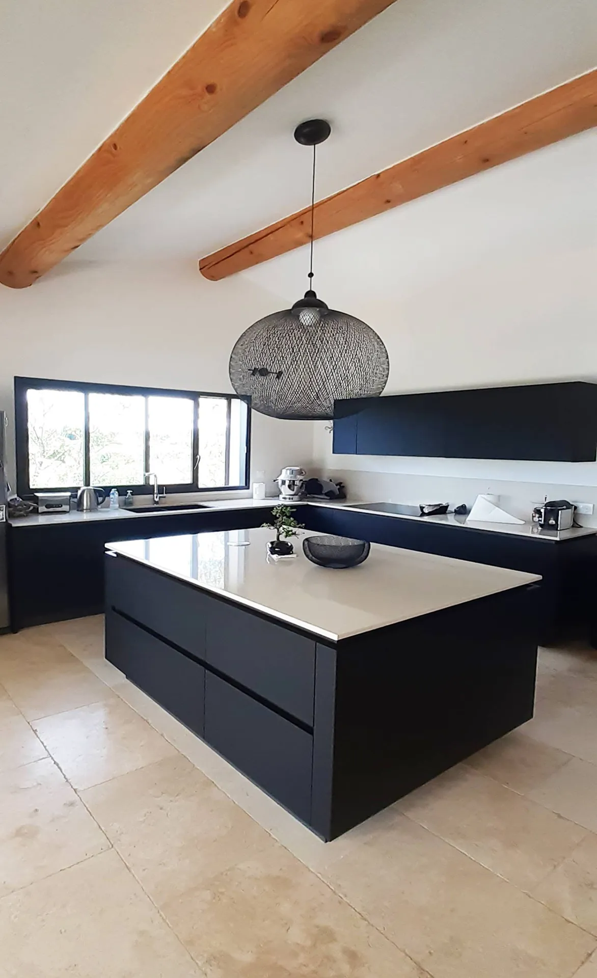Cuisine ouverte sur mesure avec ilot central et poutre de charpente bois apparente 