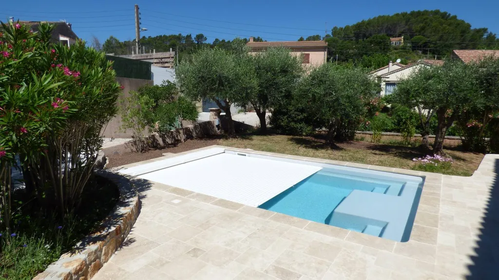 piscine avec volets déroulants dans jardin terrassé