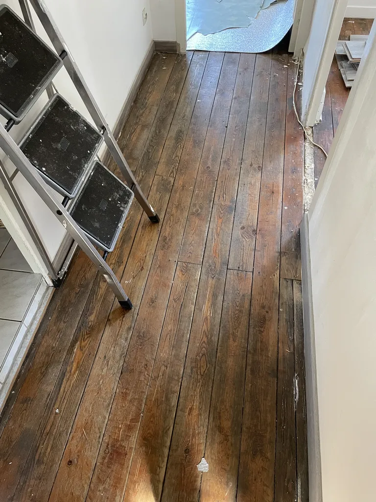 Parquet du couloir avant rénovation avec traces d’usure et teinte altérée à Belleville-en-Beaujolais
