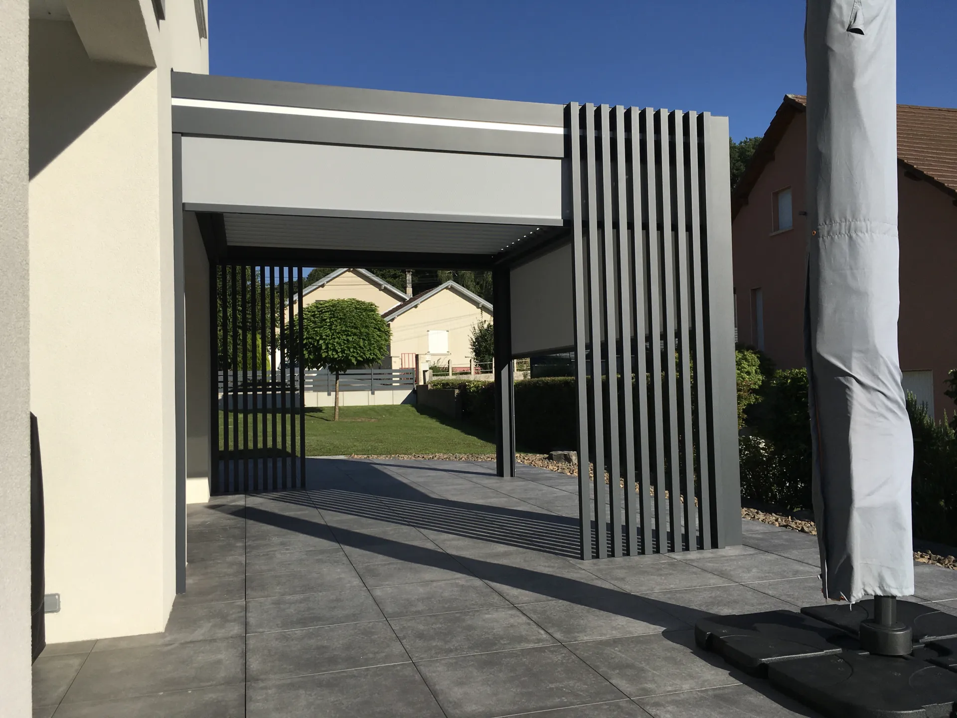 Installation d'une pergola bioclimatique aluminium adossée laqué teinte gris anthracite avec lames orientables à Seloncourt près de Belfort