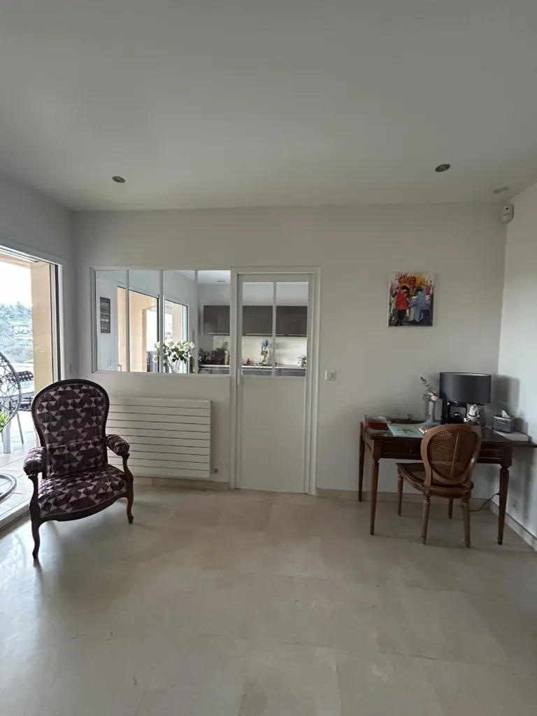 Vue côté séjour après pose de la verrière atelier séparant cuisine et pièce de vie à Collonges-au-Mont-d’Or