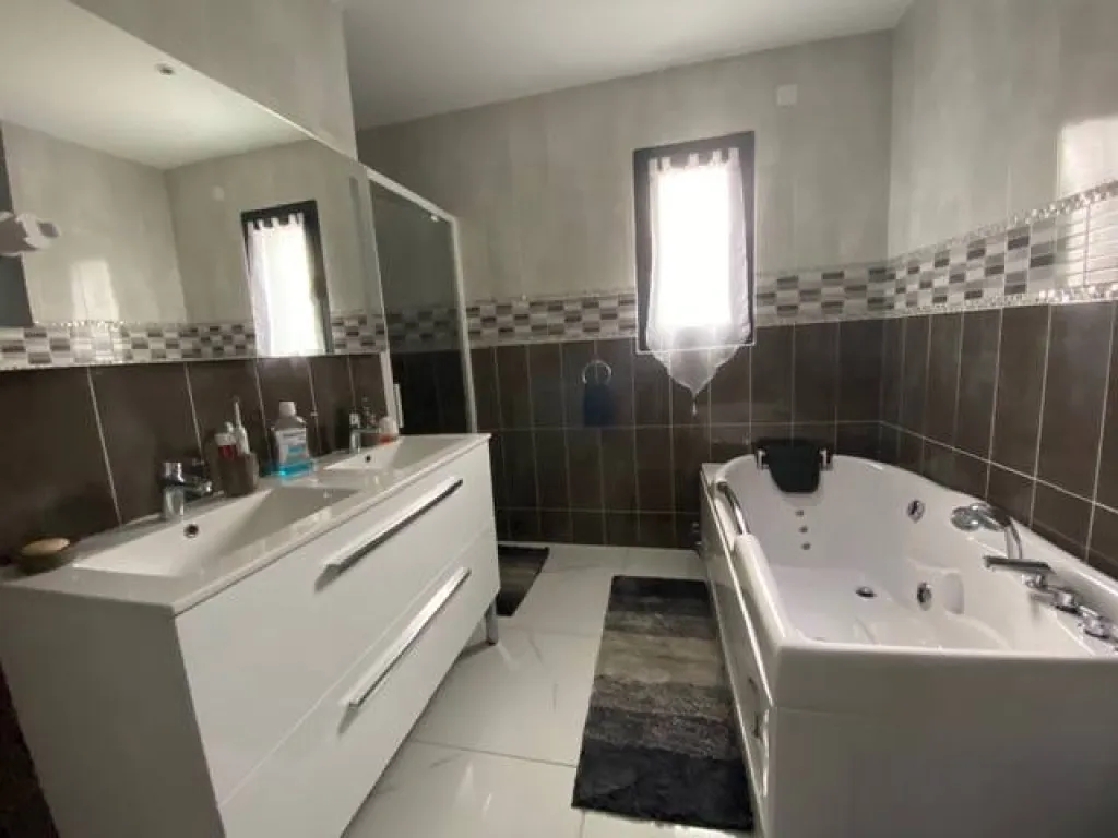 une salle de bain avec baignoire balnéothérapie et douche