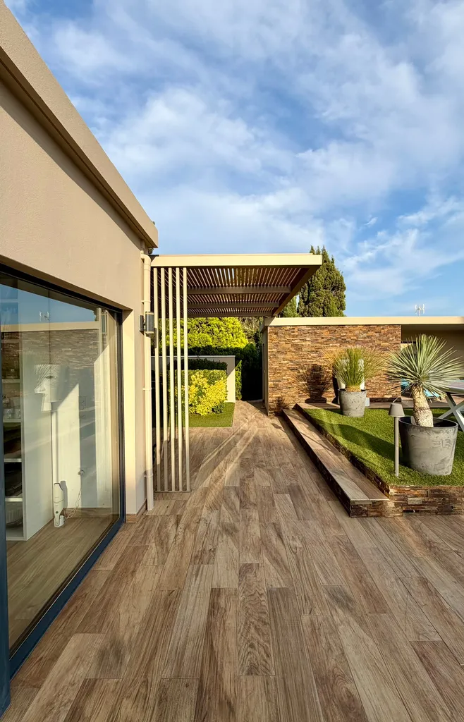 pergola en acier à sous-face à lames avec claustra vertical intégré ouvrant sur la terrasse