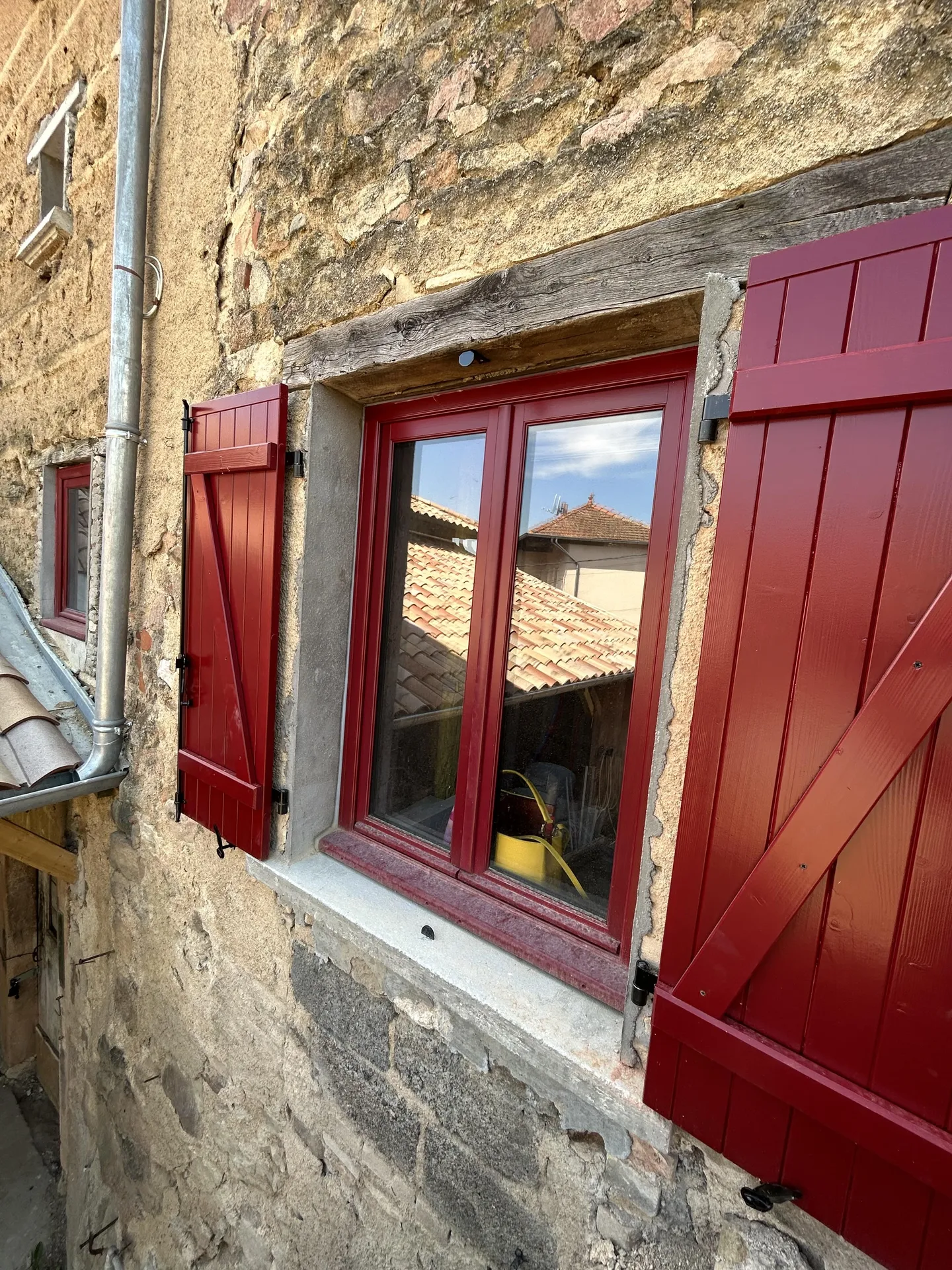 Fenêtre neuve après rénovation dans une maison en pierre et pisé permettant de réduire les déperditions de chaleur et améliorer le confort