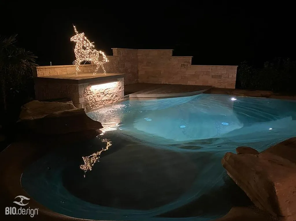 Rénovation de piscine traditionnelle en piscine lagon naturelle avec plage immergée sable quartz en Loire Saint-Étienne haut de gamme