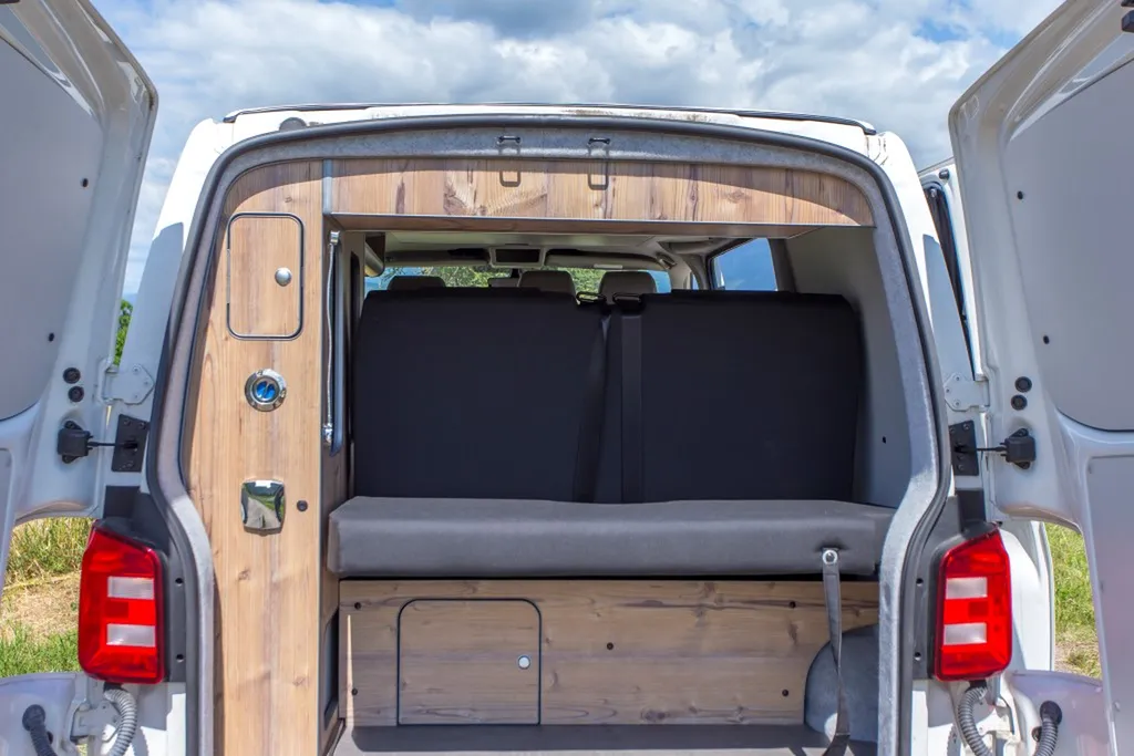 Aménagement intérieur sur-mesure VW Transporter T6 Court avec banquette Reimo et finition bois vieilli à Chambéry en Savoie
