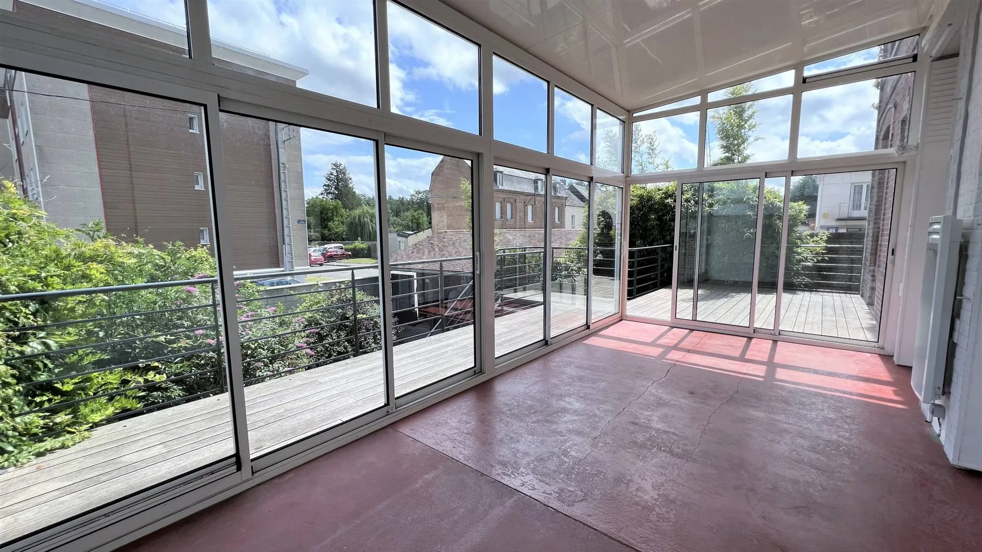 Une grande véranda donnant sur la terrasse bois en plateforme