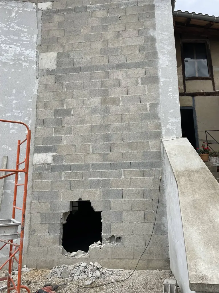Découpe et ouverture du mur porteur en moellons lors des travaux de rénovation de cette maison à Montmerle-sur-Saône