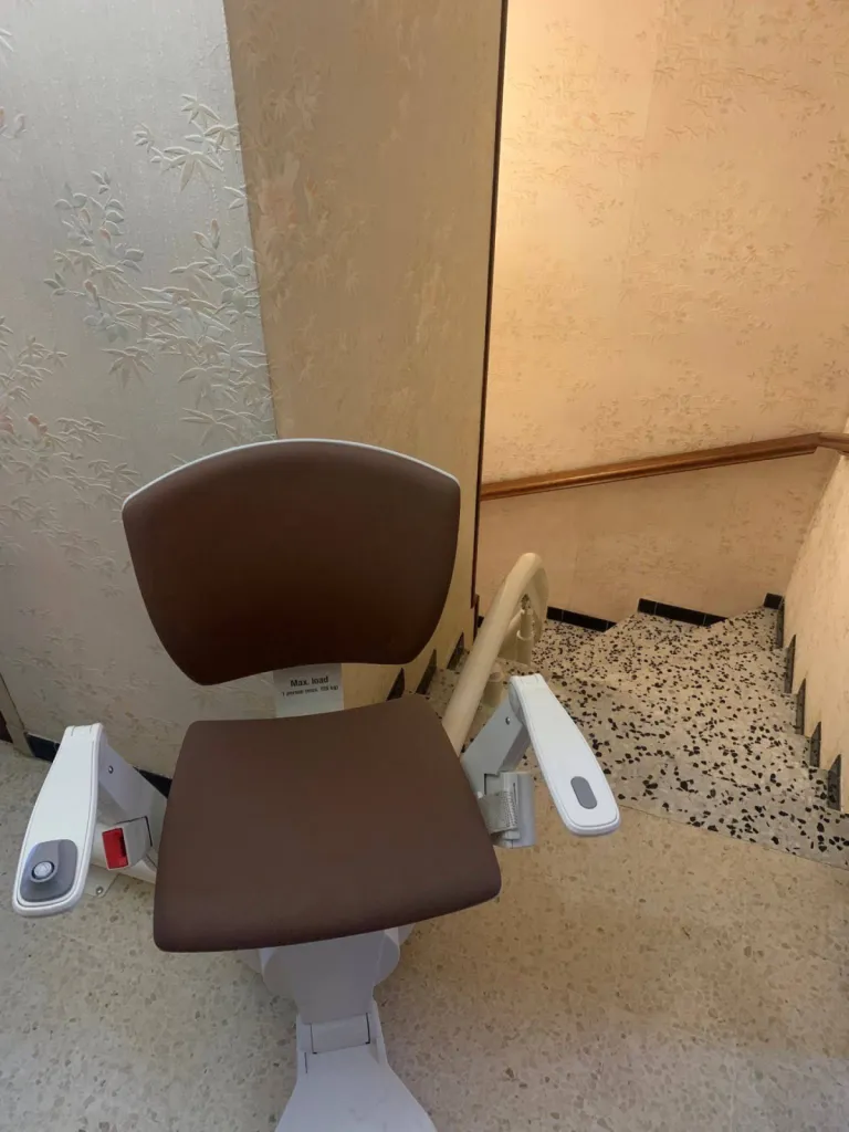 Commandes simplifiées et ergonomiques pour ce fauteuil monte-escalier monorail OTOLIFT Modul'Air en intérieur à six fours dans le Var entre Toulon & Marseille