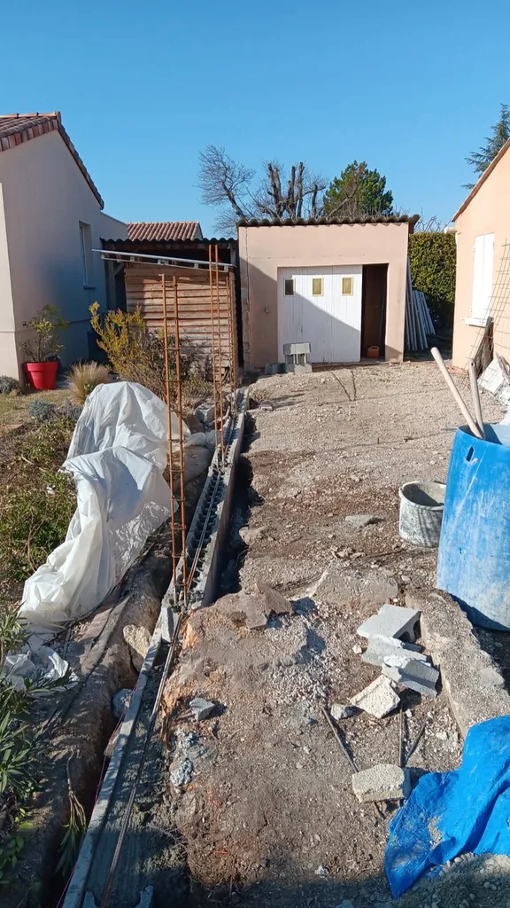 Démolition d'un ancien mur pour construire un mur de clôture