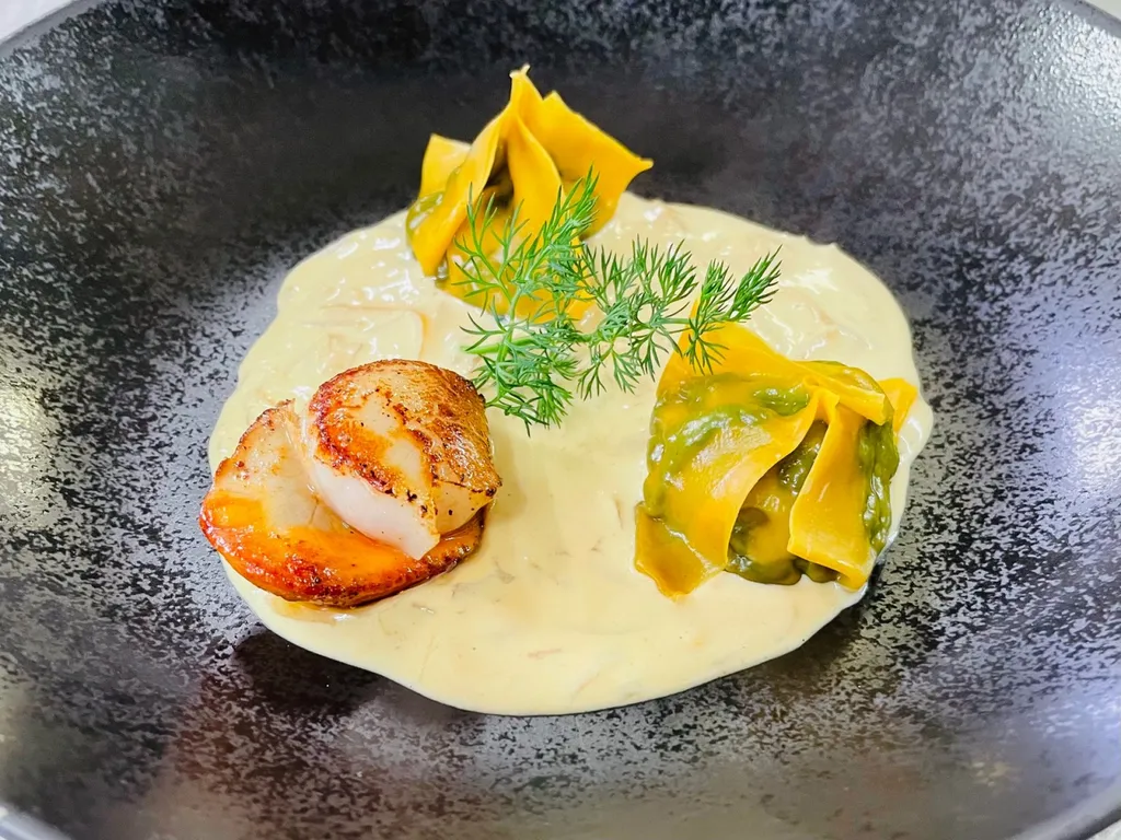 Ravioles de pousses d'épinards, noix de Saint-Jacques snackées dans une crème de moules.