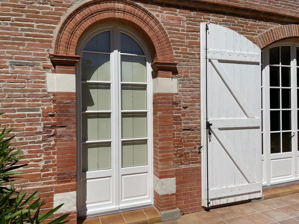 Installation de fenêtre en bois sur mesure à Toulouse cintrée avec double vitrage pour avoir une meilleure isolation phonique