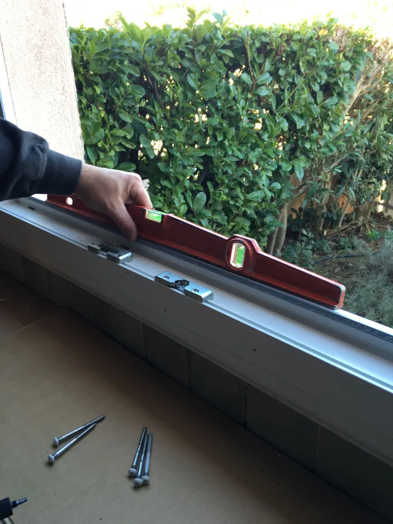 PENDANT La pose du niveau sur dormant de la fenêtre