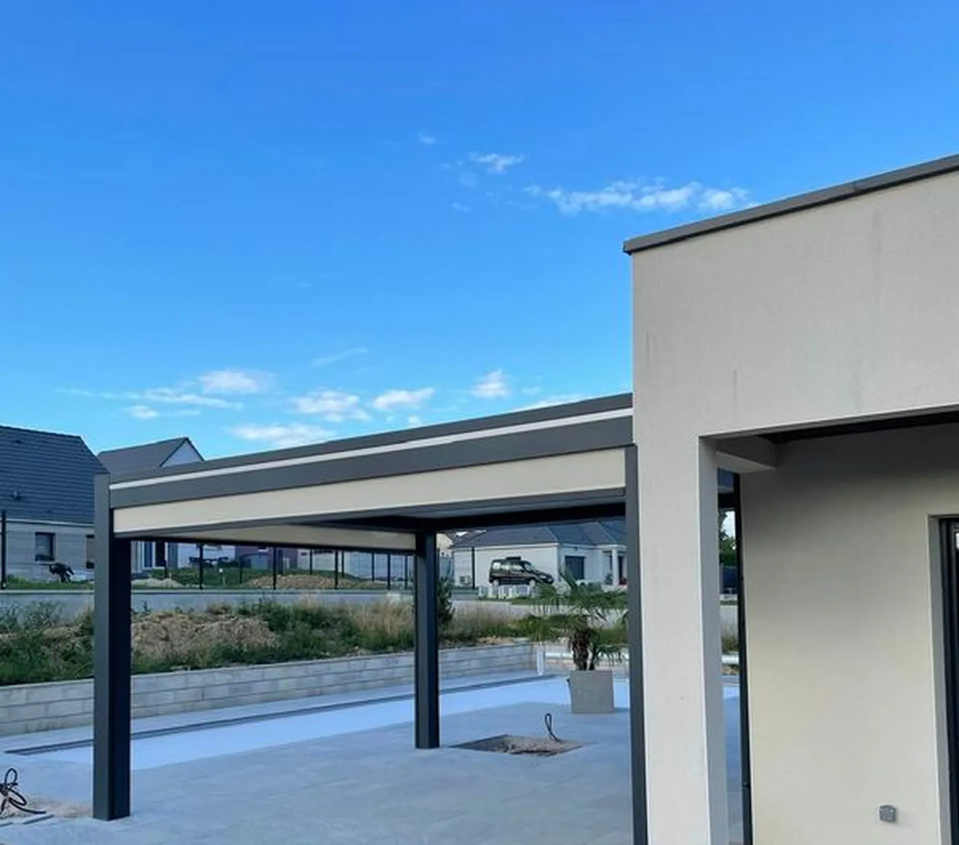 Pergola bioclimatique en aluminium à Andelnans attenante gris 7016 avec strip LED installée à Andelnans dans le Territoire de Belfort. 