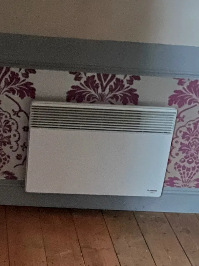 Ancien radiateur électrique énergivore dans un appartement à Lyon avant rénovation du chauffage