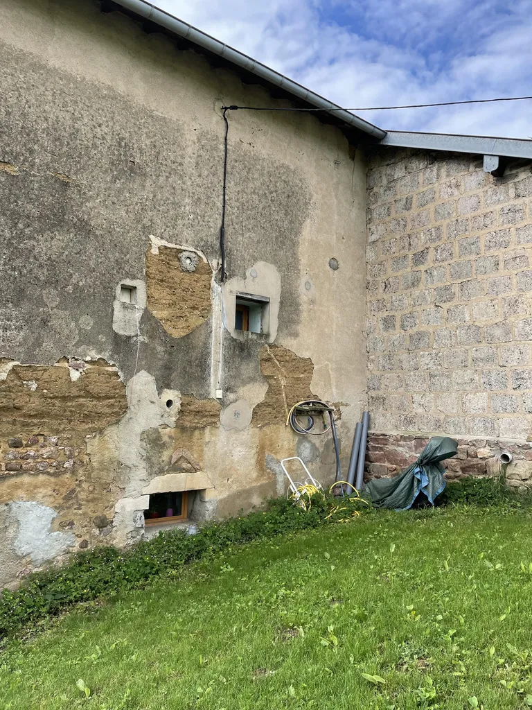 Façade d'une maison en pisé avant travaux de rénovation énergétique à Mâcon (71)