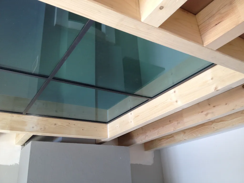 Création d’un plancher en verre feuilleté haute résistance avec vue plongeante sur la cheminée du rez-de-chaussée dans cette maison de l’Ouest lyonnais