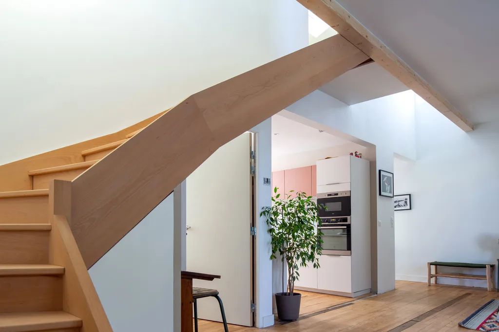 Escalier sur mesure conçu par AKIKO ARCHITECTURE pour accéder aux deux chambres créées grâce à la surélévation arrière en bardage fibro-ciment, signature du projet dans le quartier Bastide à Bordeaux