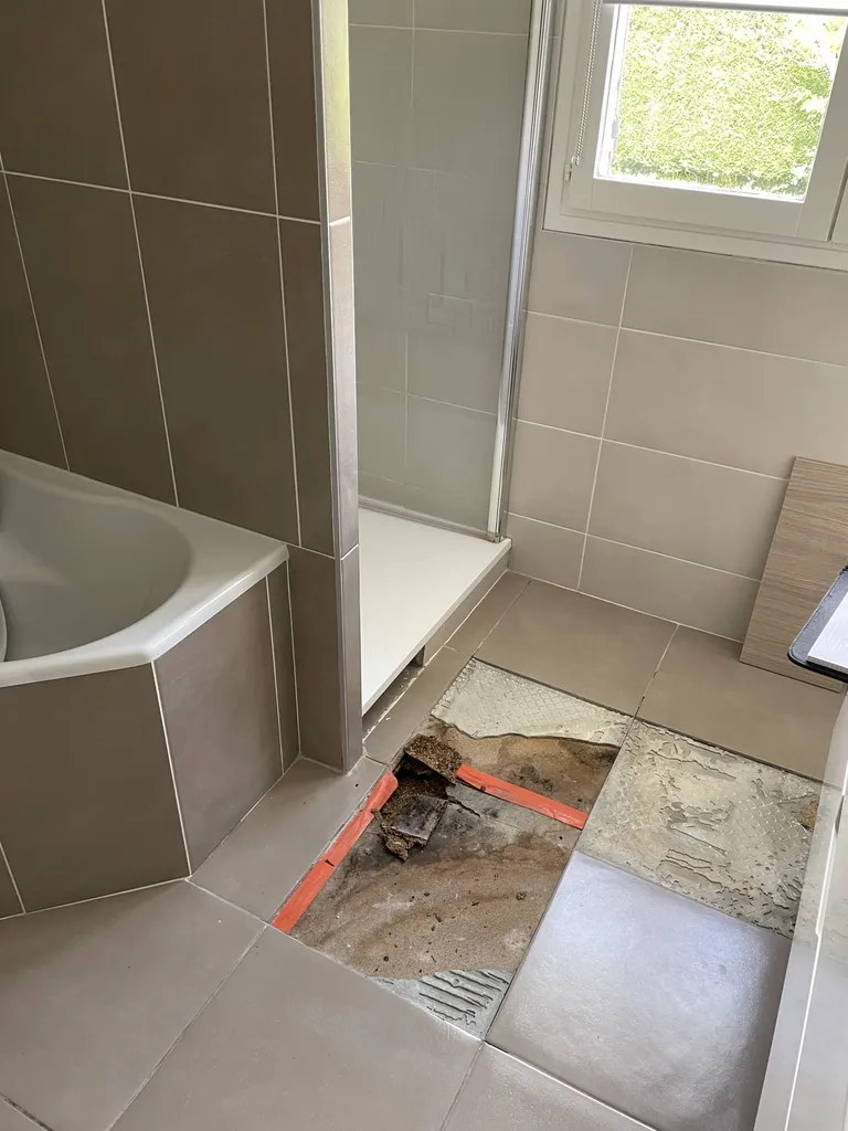 Plancher fortement endommagé par un dégât des eaux avant les travaux de rénovation complète de la salle de bain à Genay (69).
