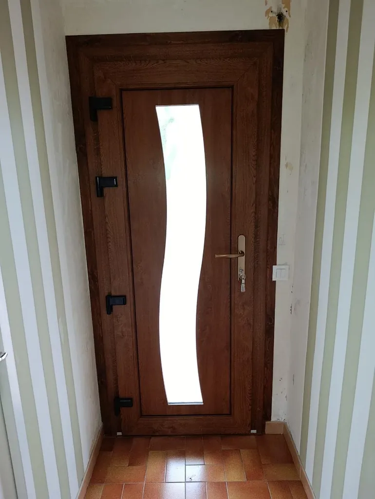 Installation d'une porte d'entrée en PVC sur mesure, haute sécurité avec vitrage décoratif, finition chêne doré à Chevigny-Saint-Sauveur