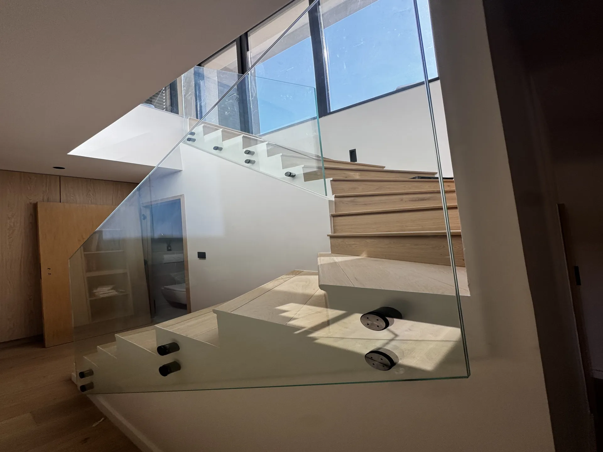 Garde-corps en verre et bois, fixation Sadev noire, sublimant un escalier lumineux à Vourles.