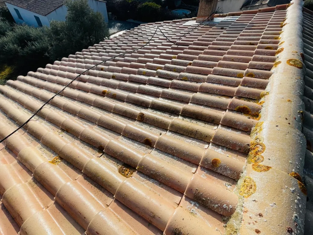 Nettoyage et traitement des tuiles mécaniques Romane d’une toiture de maison près d’Aix en Provence.