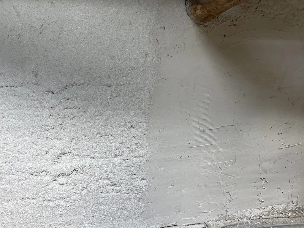 Zoom sur la finition d'un isolant biosourcé sur une maison traditionnelle en pisé