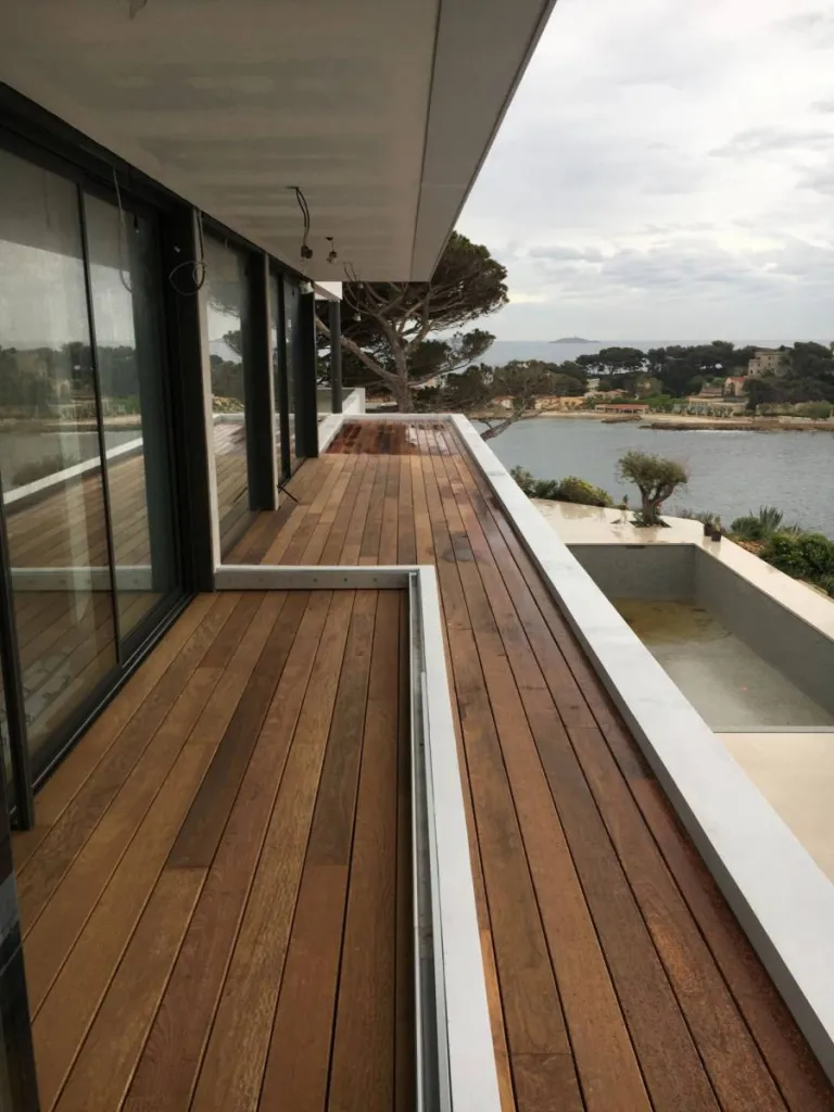 Finition haut de gamme avec lames en bois exotique Ipé posées sur plots et lambourdes, pour une terrasse élégante et résistante aux intempéries.