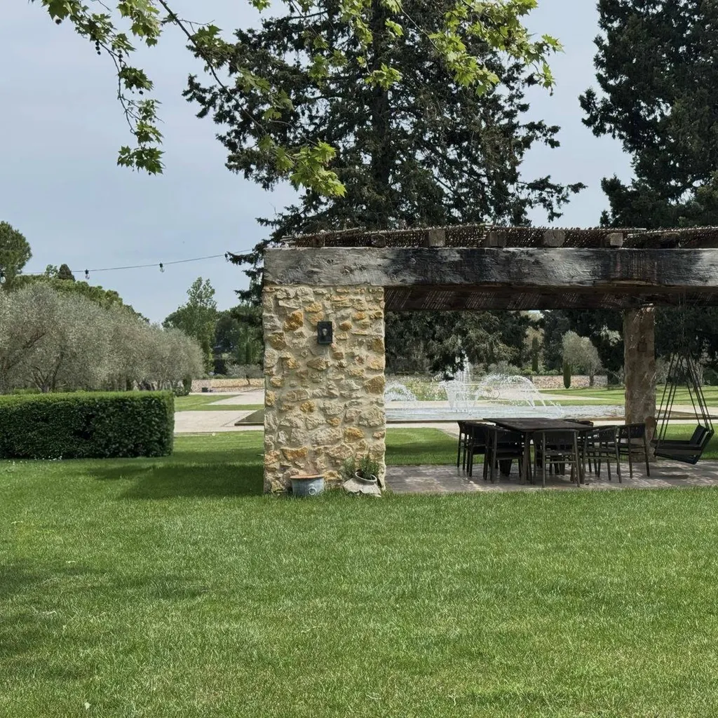 Pergola ombragée et fontaine en arrière-plan, jardin entretenu à Aix-en-Provence (13100).