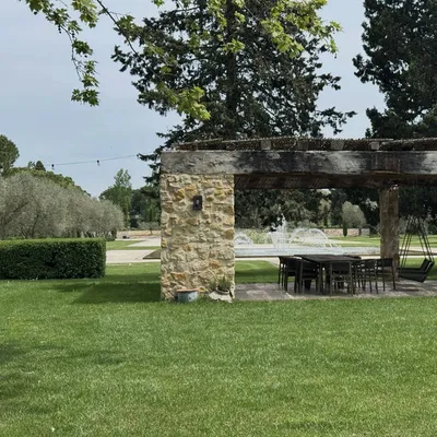Pergola ombragée et fontaine en arrière-plan, jardin entretenu à Aix-en-Provence (13100).