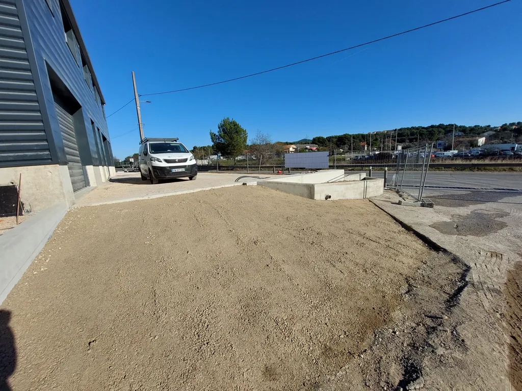 Réalisation du parking d'un entrepôt en enrobé de bitume noir à Septême les Vallons dans les Bouches du Rhône