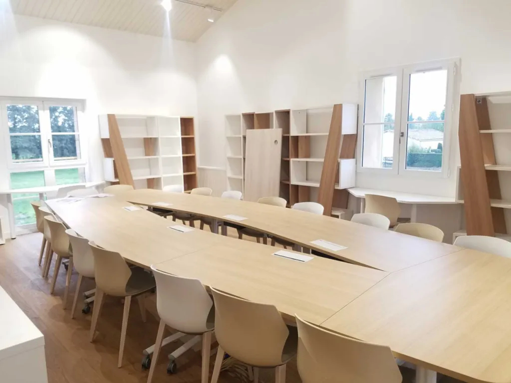 Réhabilitation de 200 m² de bureaux à Cheval-Blanc avec table de réunion 20 places, cafétéria colorée et design bois/blanc chaleureux
