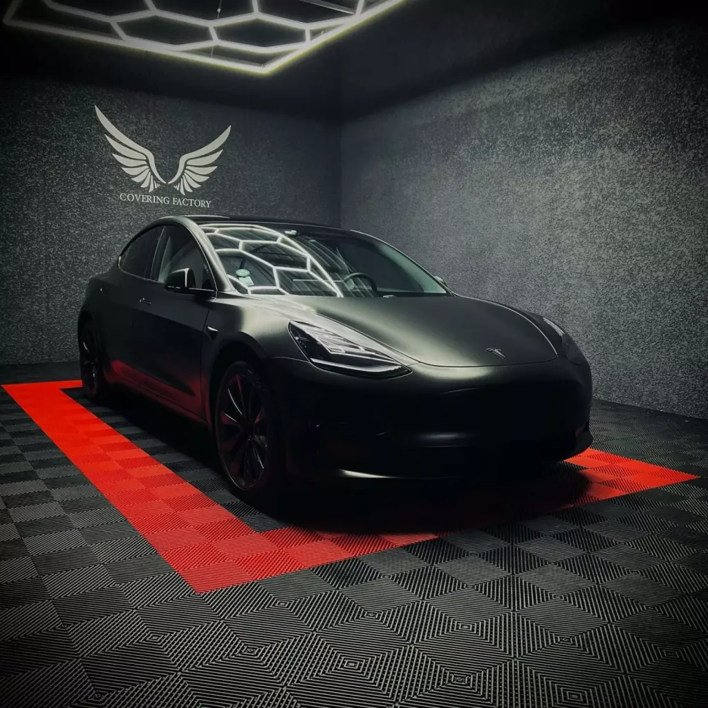 Covering complet noir satin pour cette Tesla Model 3 avec phares avant teintés en PPF Xpel et phares arrière teintés à Lyon
