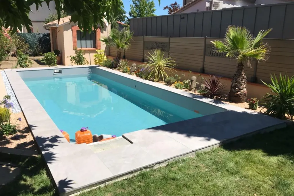Paysagiste pour pose de dalles en grès céramique pour une réalisation de terrasse de piscine à Colomiers
