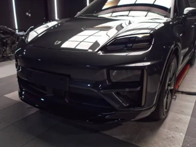 Application précise du PPF film de protection XPEL sur les ailes avant du Porsche Macan E 2025 pour préserver la peinture