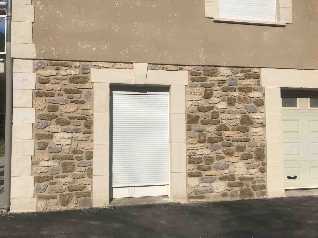 Façade en pierre taillee avec torchis gratté à l’ancienne sur l’étage à Saint-Pons de Thomières