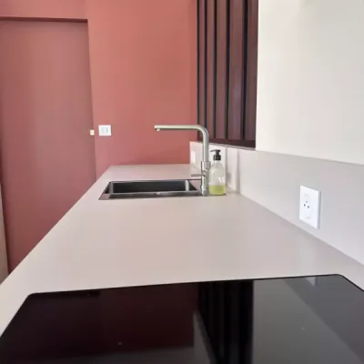 Cuisine avec plan de travail effet pierre et robinetterie dorée, par l’Atelier D. architecte d’intérieur à Bordeaux.