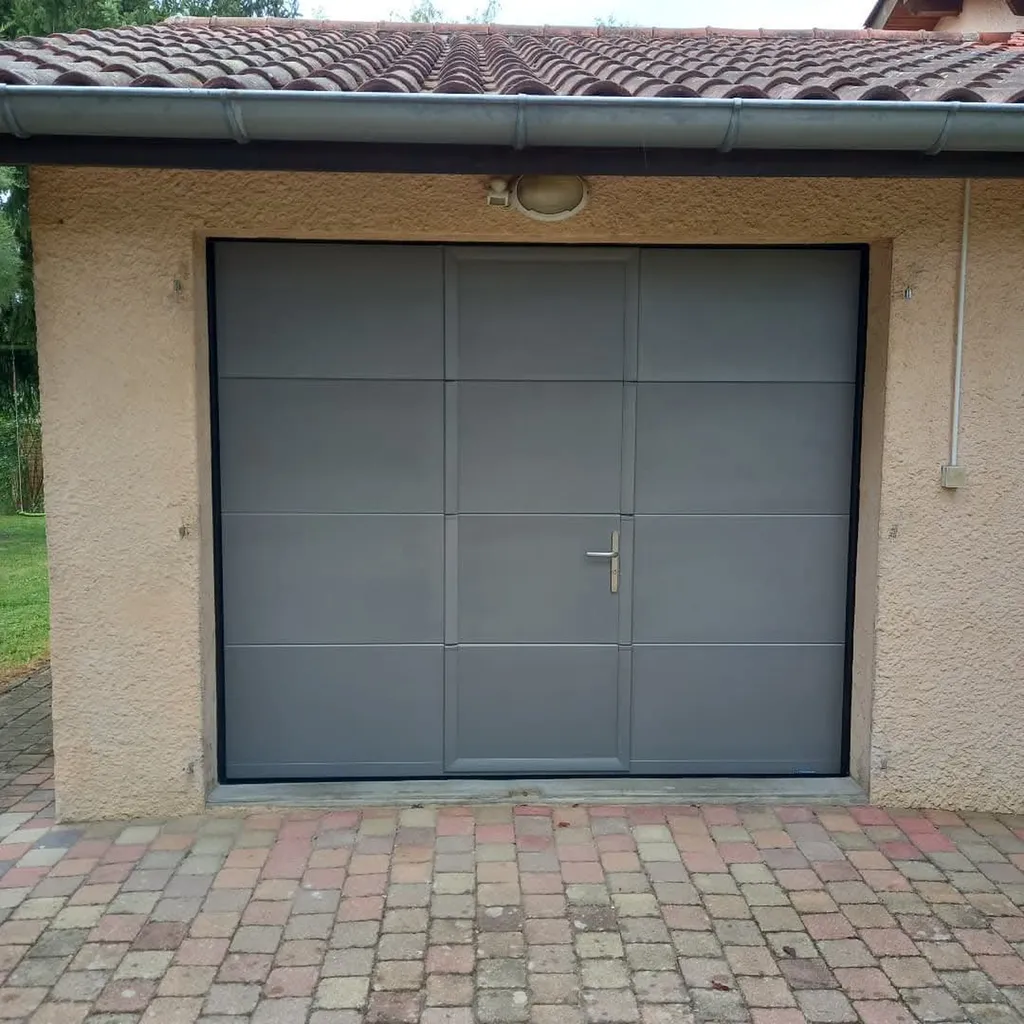 Installation d'une porte de garage sectionnelle isolée motorisée avec portillon intégré et serrure de sécurité à Misérieux