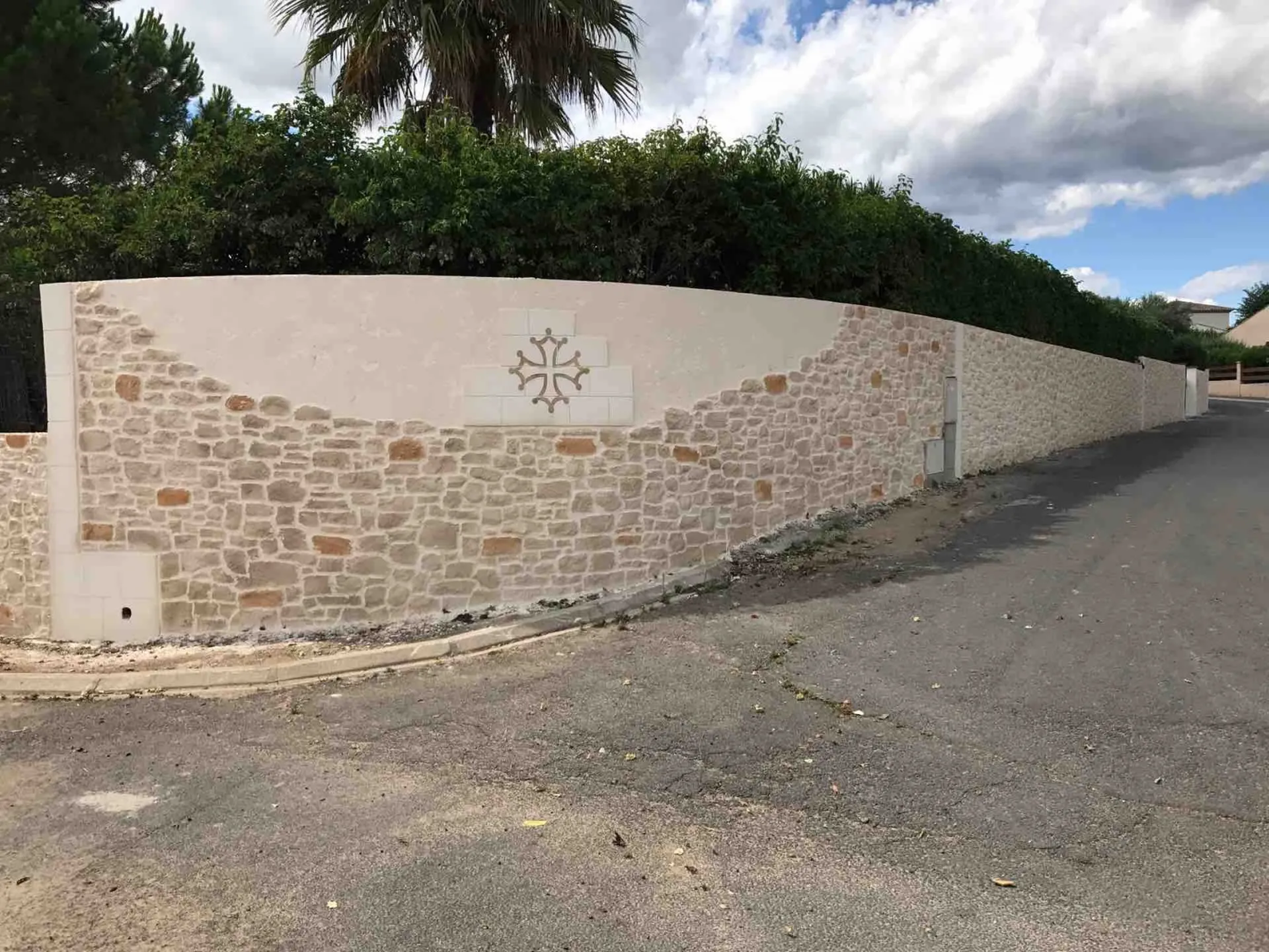 Clôture en pierre taillée avec cascade  et motif à Alignan du vent dans l'Hérault