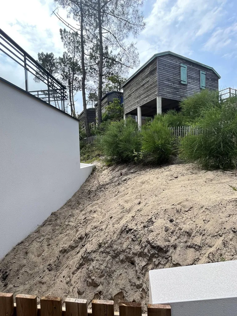 Création par Evolution Paysage d'une retenue de sable avec des traverses en chêne à Mimizan