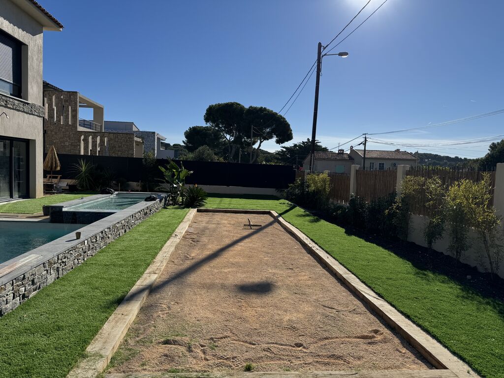 Création d’un jardin paysager avec gazon synthétique, palmiers et arrosage automatique pour villa à Sanary-sur-Mer