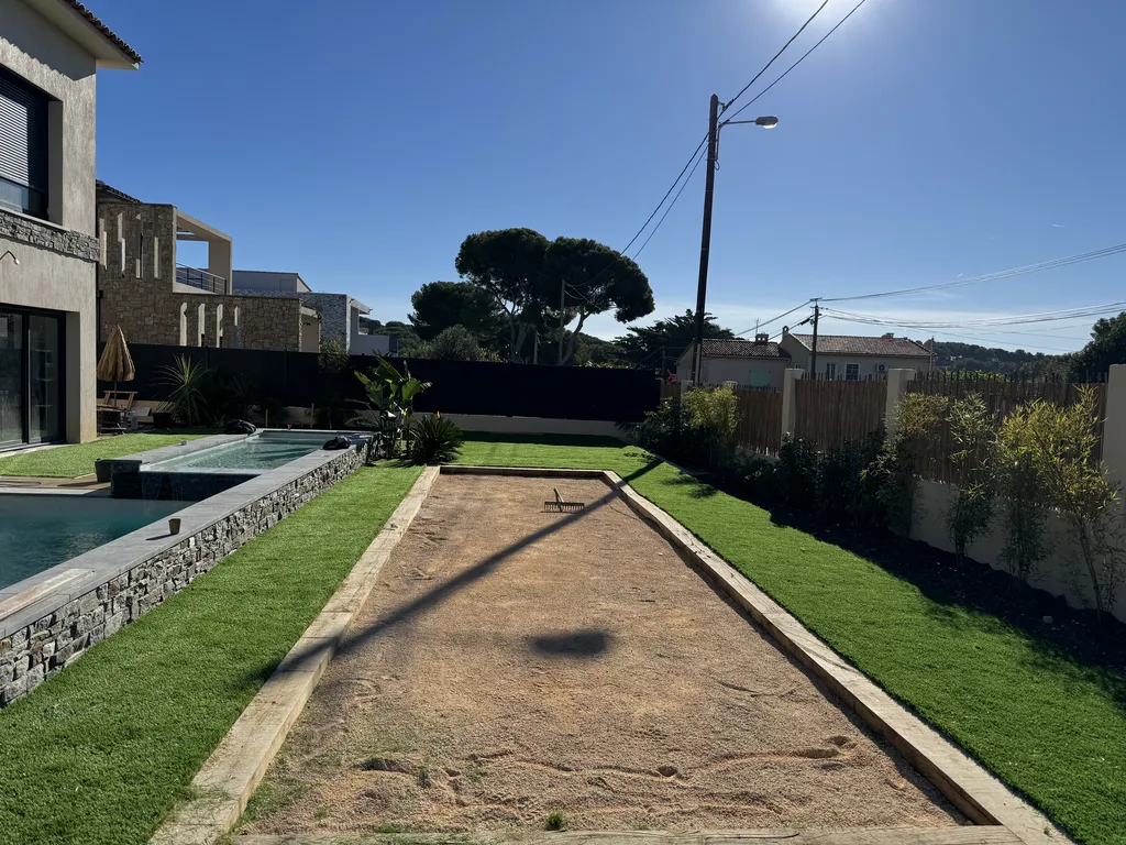 Création d’un jardin paysager avec gazon synthétique, palmiers et arrosage automatique pour villa à Sanary-sur-Mer